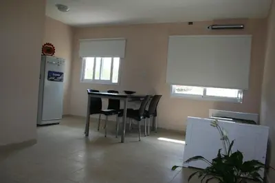 a kitchen with a table and chairs and a refrigerator at La Catalina Traslasierra in Nono