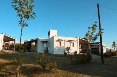 a white house with a tree in front of it at La Catalina Traslasierra in Nono