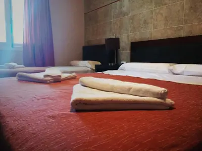 two beds in a hotel room with towels on the floor at Hotel Sierras in Mina Clavero
