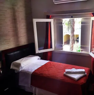 a bedroom with a bed and a window at Hotel Sierras in Mina Clavero