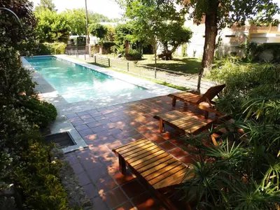 two wooden benches sitting next to a swimming pool at Hotel Sierras in Mina Clavero