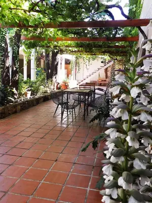 a patio with a table and chairs under a pergola at Hotel Sierras in Mina Clavero