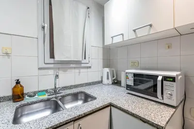 a kitchen with a sink and a microwave at Lofty Departamentos Temporarios in Cordoba