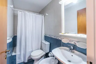 a bathroom with a white toilet and a sink at Lofty Departamentos Temporarios in Cordoba