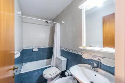 a bathroom with a toilet and a sink and a bath tub at Lofty Departamentos Temporarios in Cordoba