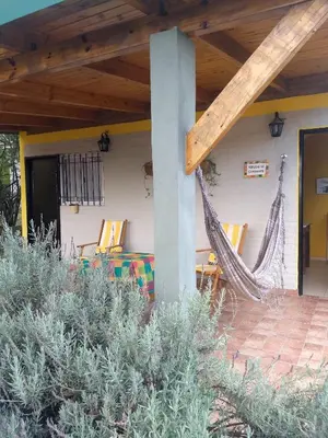 a hammock on the porch of a house at Cabaña Refugio De Caminantes in Tanti