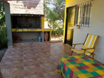 a patio with a fireplace and a chair and a table at Cabaña Refugio De Caminantes in Tanti