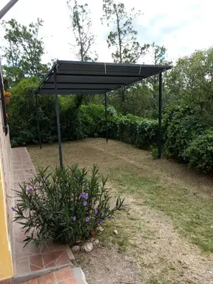 a black canopy in a yard with a plant at Cabaña Refugio De Caminantes in Tanti