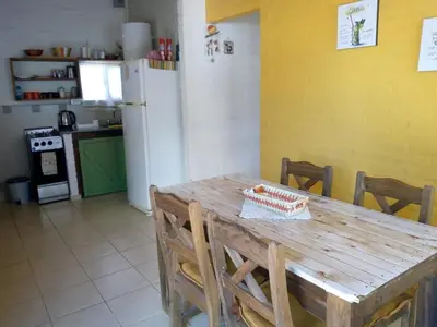a wooden table in a kitchen with a refrigerator at Cabaña Refugio De Caminantes in Tanti