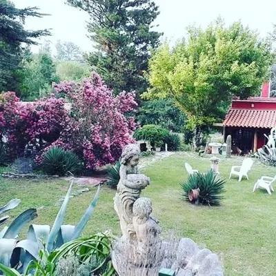 a garden with two statues in the grass at Quinta Santana in José de la Quintana