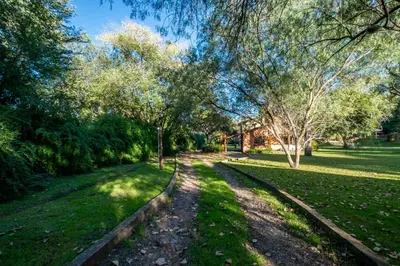 a path in a park with trees and grass at Grenouille in Villa General Belgrano