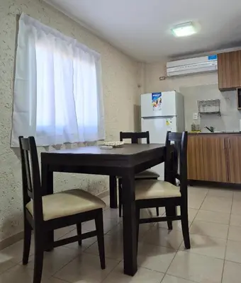 a table and chairs in a kitchen with a refrigerator at Solares de Tanti in Tanti Nuevo