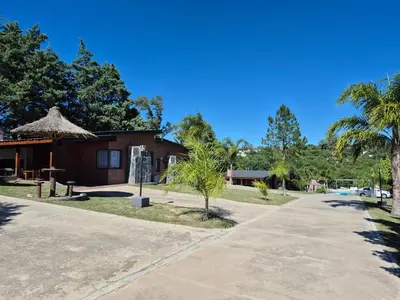 a building with a palm tree and a sidewalk at Solares de Tanti in Tanti Nuevo