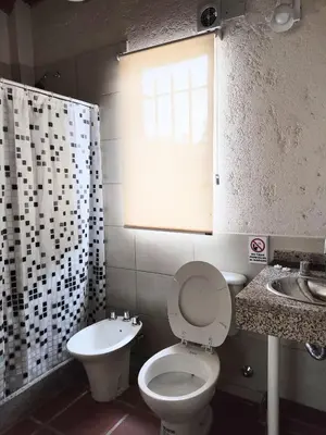a bathroom with a toilet and a sink and a window at Solares de Tanti in Tanti Nuevo