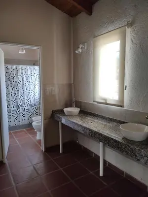 a bathroom with two sinks and a toilet and a window at Solares de Tanti in Tanti Nuevo