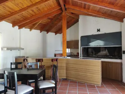 a kitchen with a bar with a table and chairs at Solares de Tanti in Tanti Nuevo