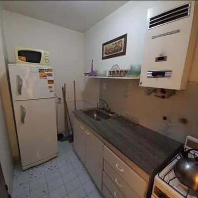 a small kitchen with a sink and a refrigerator at Edificio Trebol - Departamento en pleno centro de Carlos Paz in Villa Carlos Paz
