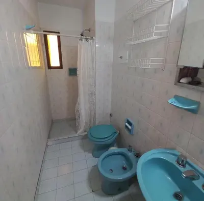 a bathroom with a blue toilet and a sink at Edificio Trebol - Departamento en pleno centro de Carlos Paz in Villa Carlos Paz