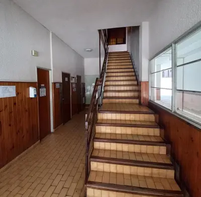 a staircase in a building with wooden floors and doors at Edificio Trebol - Departamento en pleno centro de Carlos Paz in Villa Carlos Paz