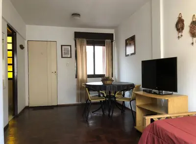 a living room with a table and a television at Edificio Trebol - Departamento en pleno centro de Carlos Paz in Villa Carlos Paz