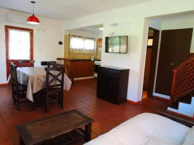 a living room with a table and a kitchen at Complejo los Espinillos de Merlo in Merlo