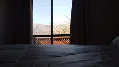 a bedroom with a bed and a window with a view at Complejo los Espinillos de Merlo in Merlo