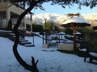 a snow covered yard with benches and an umbrella at Mirador Serrano in Merlo