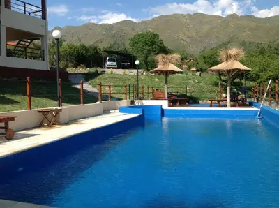 a large swimming pool with blue water and umbrellas at Mirador Serrano in Merlo