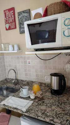 a kitchen counter with a microwave and a sink at Mirador Serrano in Merlo