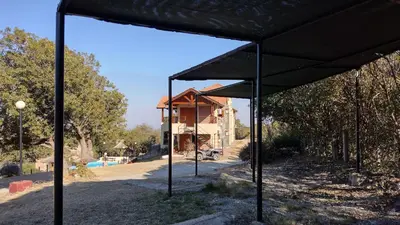 a black pavilion in front of a house at Mirador Serrano in Merlo