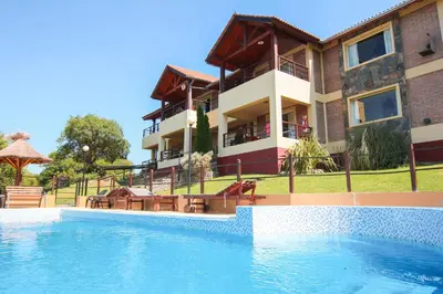 a resort with a swimming pool in front of a building at Mirador Serrano in Merlo