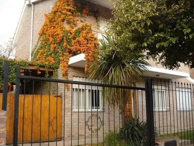 a house with orange flowers on the side of it at Casa Villa Carlos Paz in Villa Carlos Paz