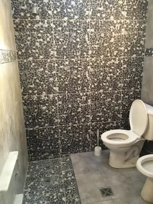 a bathroom with a toilet and a tiled wall at Casa Villa Carlos Paz in Villa Carlos Paz