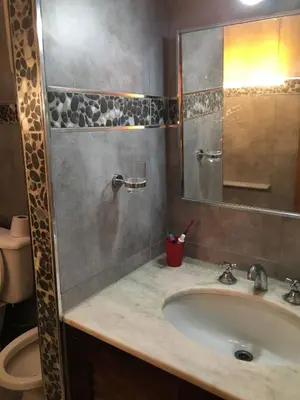 a bathroom with a sink and a mirror and a toilet at Casa Villa Carlos Paz in Villa Carlos Paz