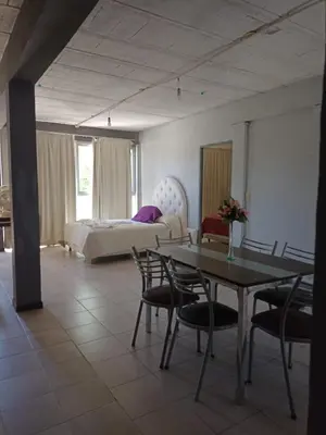 a room with a bed and a table and chairs at Complejo Navi in Mina Clavero