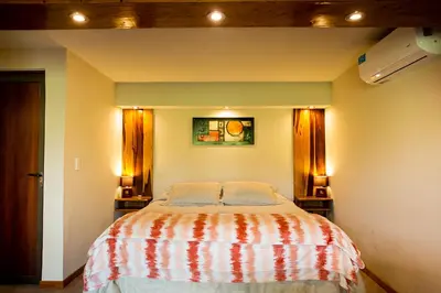 a bedroom with a bed with two pillows on it at SUITES ALITHUÉ in La Cumbrecita