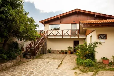 a house with a staircase in front of it at SUITES ALITHUÉ in La Cumbrecita