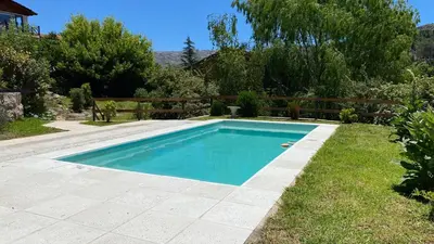 a swimming pool in the yard of a house at SUITES ALITHUÉ in La Cumbrecita