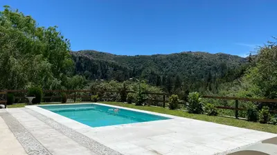 a swimming pool with a view of a mountain at SUITES ALITHUÉ in La Cumbrecita