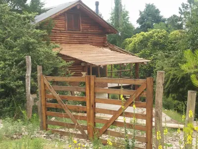 a wooden cabin with a gate and a fence at Cabaña Atha Iti in Villa General Belgrano