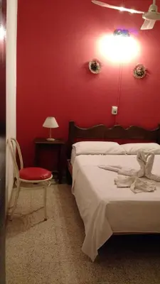 a bedroom with red walls and a bed and a chair at Residencial Castelar in Merlo