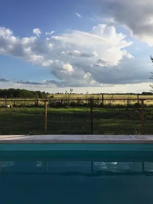 a swimming pool with a view of a field and a fence at La Antonia Elvira in Los Reartes