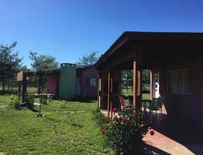 a house with a porch and a yard with flowers at La Antonia Elvira in Los Reartes