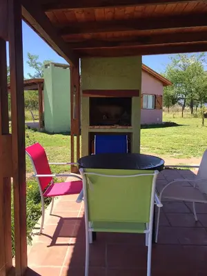 a patio with a table and chairs and a fireplace at La Antonia Elvira in Los Reartes