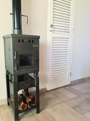 a stove in a room next to a door at La Antonia Elvira in Los Reartes