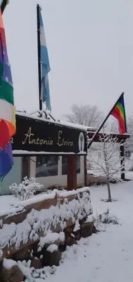 a sign in the snow in front of a building at La Antonia Elvira in Los Reartes