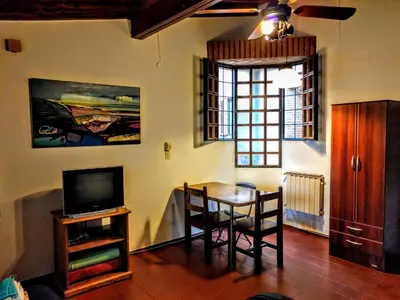 a dining room with a table and a television at Cozy apartment in Cordoba in Cordoba