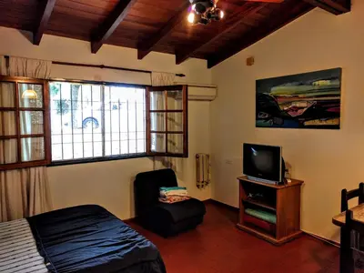 a bedroom with a bed and a tv and a chair at Cozy apartment in Cordoba in Cordoba