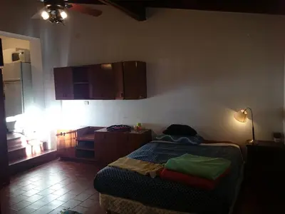 a bedroom with a bed and a kitchen with a light at Cozy apartment in Cordoba in Cordoba