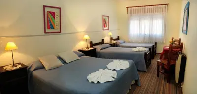 a hotel room with two beds with towels on them at Embajador Hotel in Villa Carlos Paz